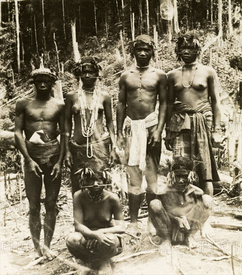 Aboriginal people of northern Malaysia. A group of semi-naked aborigines from the forests of northern Malaysia pose for the camera at Ulu Ringat. They wear wreaths of leaves on their heads and are adorned with jewellery: the women having pierced their noses with long sticks. Upper Perak, British Malaya (Malaysia), 1900., Perak, Malaysia, South East Asia, Asia.
