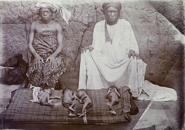 Nigerian couple with newborn babies. Portrait of a Nigerian couple with four naked newborn babies. Probably Badagry, Nigeria, circa 1928. Nigeria, Western Africa, Africa.