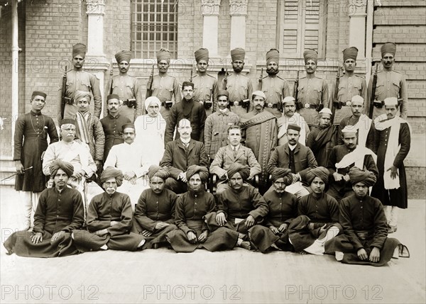 Bank of Bengal staff. Group portrait of European and Indian office staff, peons and guards, probably of a branch of the Bank of Bengal. India, circa 1905. India, Southern Asia, Asia.