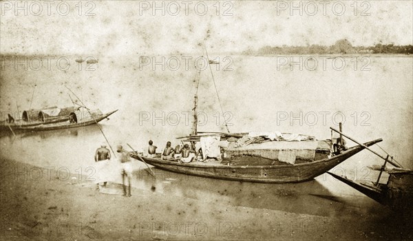 Fishing boats near Chandernagore. A small fishing boat, manned by a crew of four, waits for the off on a sandbank on the River Ganges. Several smaller, covered dinghies are moored in the background. Near Chandernagore, India, 1890., West Bengal, India, Southern Asia, Asia.