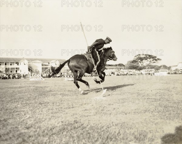 Mounted police tournament. A uniformed police officer identified as 'Constable Mitchell' rides his horse 'Mischief' in a mounted police tournmanet being held at the Eve Leary parade ground. Georgetown, Guyana, 1948. Georgetown, Demerara-Mahaica, Guyana, South America, South America .