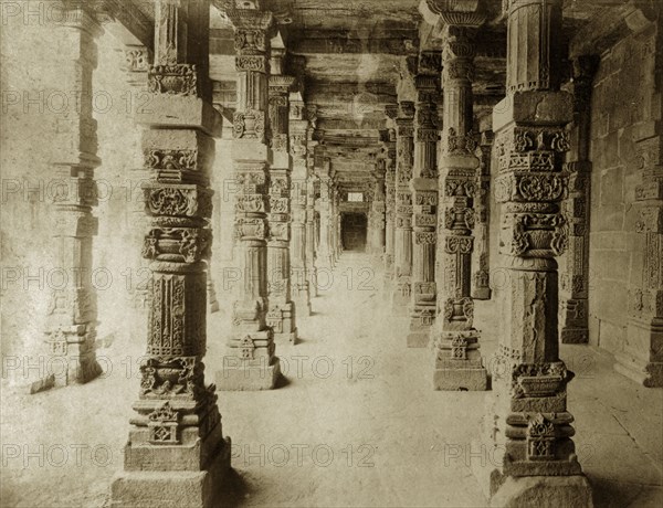 Carved pillars at the Quwwat-ul-Islam Mosque. Intricately carved stone pillars line a passageway at the Quwwat-ul-Islam Mosque. Delhi, India, circa 1885. Delhi, Delhi, India, Southern Asia, Asia.