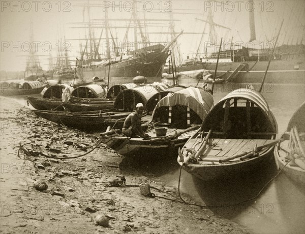 Sampans on the Hooghly River. A number of small sampans are tied up on the banks of the Hooghly River, with several East Indiamen sailing ships in the distance. Calcutta (Kolkata), India, circa 1890. Kolkata, West Bengal, India, Southern Asia, Asia.