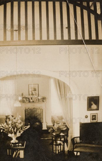 Drawing room of a colonial house, Peru. Interior shot of the drawing room in a house belonging to Archie Cooper, Chief Executive Officer of the Peruvian Corporation, located in the Miraflores district of Lima. The room features tall ceilings and an ornate fireplace, and is furnished with potted flowers and framed pictures. Lima, Peru, 1920. Lima, Lima Metropolitana, Peru, South America, South America .