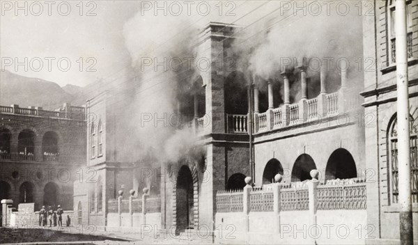 Riot damage in Aden, 1947. Smoke engulfs a building in the Jewish quarter of Aden, during the Arab riots that took place between 1-3 December 1947 in response to the United Nations Partition Plan for Palestine. Aden, Yemen, December 1947. Aden, Adan, Yemen, Middle East, Asia.
