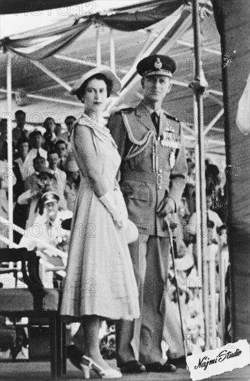 Queen Elizabeth II and the Duke of Edinburgh in Aden, 1954. Queen Elizabeth II and the Duke of Edinburgh stand together on a stage at an outdoor event in Aden, which they attended as part of a royal tour of the Commonwealth between November 1953 and May 1954. Aden, Yemen, 27 April 1954. Aden, Adan, Yemen, Middle East, Asia.