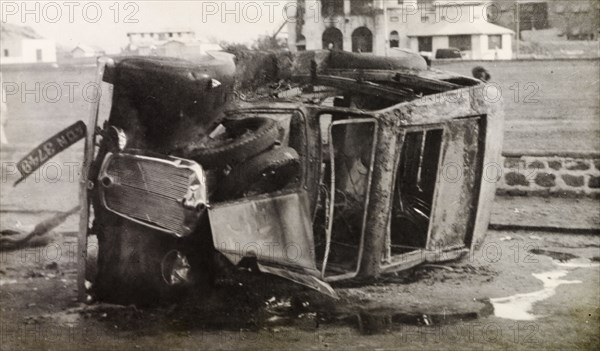 Car destroyed by Arab riots in Aden, 1947. A burnt-out car lies on its side in a street in Aden, during the Arab riots that took place between 1-3 December 1947 in response to the United Nations Partition Plan for Palestine. Aden, Yemen, December 1947. Aden, Adan, Yemen, Middle East, Asia.