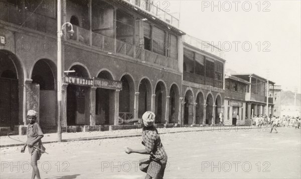 Rioting in Aden, 1947. A man takes aim in throwing an object at a bazaar in Aden, during the Arab riots that took place between 1-3 December 1947 in response to the United Nations Partition Plan for Palestine. Aden, Yemen, December 1947. Aden, Adan, Yemen, Middle East, Asia.