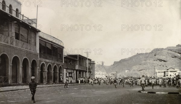Rioting in Aden, 1947. A large crowd of people roam a wide street in the Jewish quarter of Aden, during the Arab riots that took place between 1-3 December 1947 in response to the United Nations Partition Plan for Palestine. Aden, Yemen, December 1947. Aden, Adan, Yemen, Middle East, Asia.