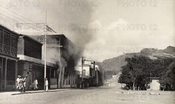 Riot damage in Aden, 1947. Smoke billows from a building in the Jewish quarter of Aden, during the Arab riots that took place between 1-3 December 1947 in response to the United Nations Partition Plan for Palestine. Aden, Yemen, December 1947. Aden, Adan, Yemen, Middle East, Asia.