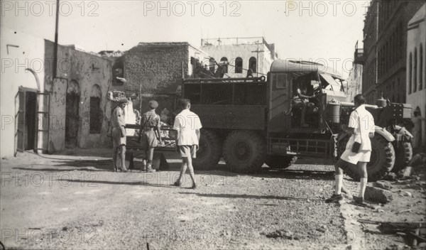Clearing up after Arab riots in Aden, 1947. Soldiers maneuver a utility truck through a street in the Jewish quarter of Aden, during a clean up operation after the Arab riots that took place between 1-3 December 1947 in response to the United Nations Partition Plan for Palestine. Aden, Yemen, December 1947. Aden, Adan, Yemen, Middle East, Asia.