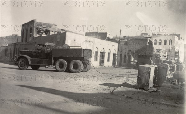 Aftermath of Arab riots in Aden, 1947. An army truck with a trailing tow rope is parked near damaged buildings in a deserted street in the Jewish quarter of Aden, after the Arab riots that took place between 1-3 December 1947 in response to the United Nations Partition Plan for Palestine. Aden, Yemen, December 1947. Aden, Adan, Yemen, Middle East, Asia.