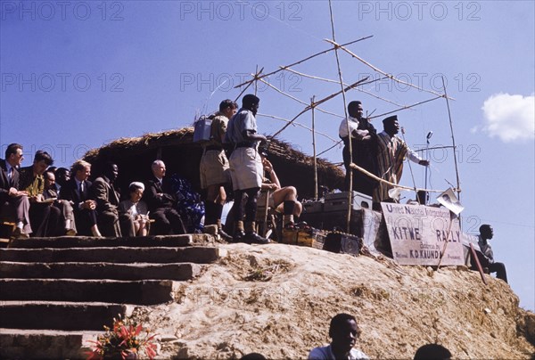 United National Indepence Party political rally. Two politicians address an unseen crowd at a political rally organized by the United National Independence Party (UNIP). A sign at the front of the podium advertises an address by UNIP President, Kenneth Kaunda. Kitwe, Northern Rhodesia (Zambia), circa 1962. Nkana-Kitwe, Copperbelt, Zambia, Southern Africa, Africa.