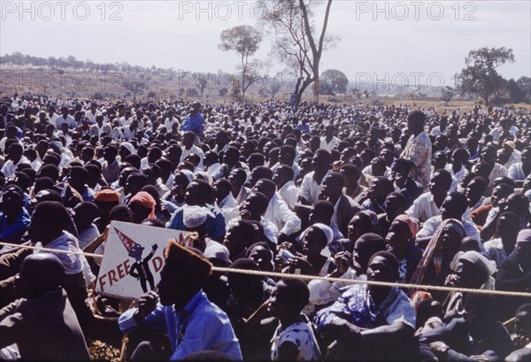 Crowd at United National Independence Party rally. A crowd of Zambian supporters sit and watch a rally by the United National Independence Party. Kitwe, Northerm Rhodesia (Zambia), circa 1962. Nkana-Kitwe, Copperbelt, Zambia, Southern Africa, Africa.