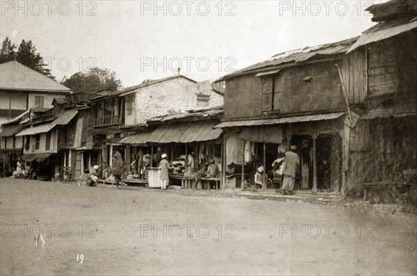Street traders at a bazaar, India. Street traders at a bazaar sell their wares from ramshackle buildings on the main street of a town. India, 1890. India, Southern Asia, Asia.