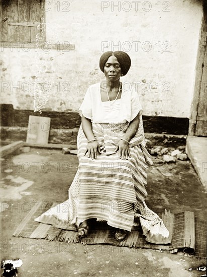 Portrait of a seated Nigerian woman. Portrait of a Nigerian woman, seated and wearing traditional dress. Probably Badagry, Nigeria, circa 1928. Badagry, Lagos, Nigeria, Western Africa, Africa.