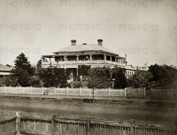 House called 'Nundora', Australia. The Brodribb family's home, 'Nundora', probably located on Herries Street. The imposing colonial house, two storeys high is surrounded by a large garden ringed with a picket fence. The house has broad verandas, a sloping roof and multiple chimneys. Toowoomba, Australia, circa 1890. Toowoomba, Queensland, Australia, Australia, Oceania.