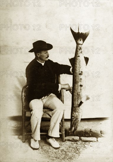 Prize fish, Andaman Islands. A European man poses proudly for the camera, displaying a large, exotic fish that he has caught. Probably Andaman Islands, India, circa 1900. India, Southern Asia, Asia.