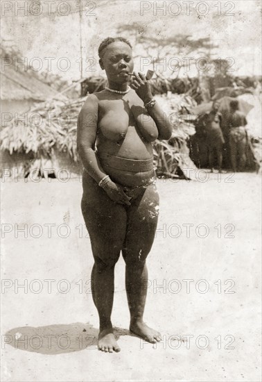 Woman from the Andaman Islands. Portrait of a semi-naked woman from the Andaman Islands smoking a clay pipe. Andaman Islands, India, circa 1900., Andaman and Nicobar Islands, India, Southern Asia, Asia.