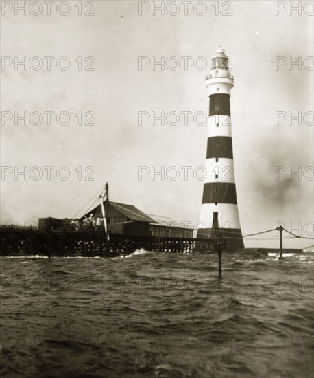 Alguada Reef lighthouse. The striped Alguada Reef lighthouse towers above rough sea waters in the Bay of Bengal. Burma (Myanmar), circa 1900. Burma (Myanmar), South East Asia, Asia.