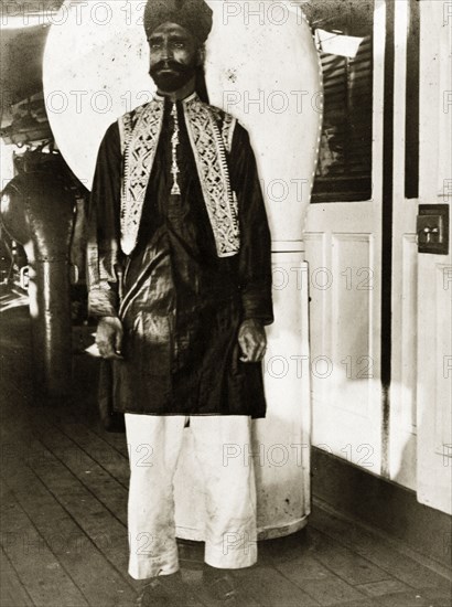 A workshop labourer all dressed up. A workshop labourer dressed in his finest clothes aboard a naval ship, a vessel that was probably part of the Persian Gulf Operations Fleet. Probably the Persian Gulf, circa 1900., Middle East, Asia.