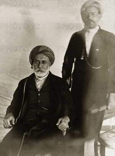 Officials of Lingah. Portrait of two officials from Qeshm Island dressed in Western-style suits. Lingah, Qeshm Island, Persia (Iran), circa 1900. Lingah, Qeshm Island, Iran, Middle East, Asia.