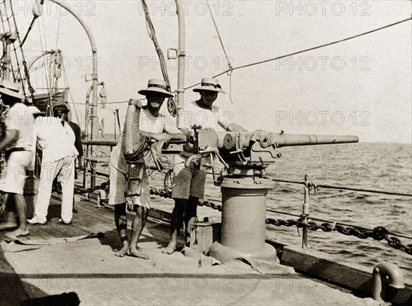 A gun on RIMS 'Minto'. British naval officers pose, leaning on a three pound gun on the deck of RIMS 'Minto'. Indian Ocean, circa 1900., Southern Asia, Asia.