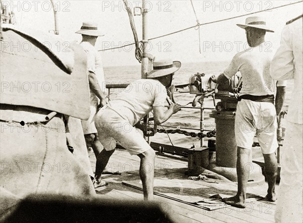 Firing a gun from RIMS 'Minto'. British naval officers fire a three pound gun on the deck of RIMS 'Minto'. Indian Ocean, circa 1900., Southern Asia, Asia.