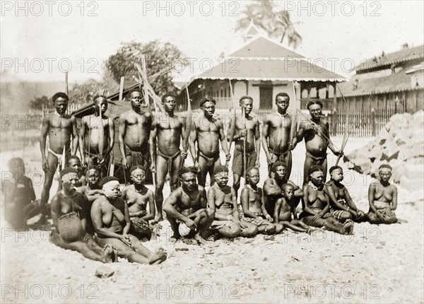 Andaman Islanders. Outdoors portrait of a group of semi-naked Andaman Islanders. The men in the back row stand with bows and arrows, smoking clay pipes. The women sit or kneel on the ground. Andaman Islands, India, circa 1900., Andaman and Nicobar Islands, India, Southern Asia, Asia.