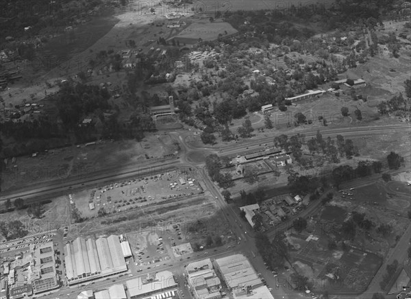 Air patrol over Littleton's town'. Aerial view taken from a patrol plane of a city identified by the photographer as 'Littleton's town'. This shot focuses on a large road intersected by a roundabout. Probably Kenya, 1 November 1952. Kenya, Eastern Africa, Africa.