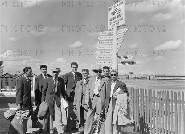 French athletics team. Members of a French athletics team pose beneath a signpost on their arrival at Eastleigh airport. Nairobi, Kenya, 9 November 1952. Nairobi, Nairobi Area, Kenya, Eastern Africa, Africa.