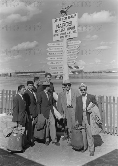 French athletics team. Members of a French athletics team pose beneath a signpost on their arrival at Eastleigh airport. Nairobi, Kenya, 9 November 1952. Nairobi, Nairobi Area, Kenya, Eastern Africa, Africa.