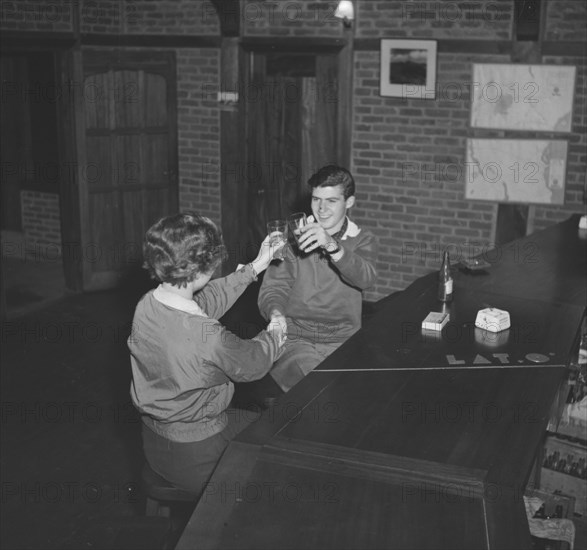 Jean and John raise a toast. A couple identified as 'Jean and John' raise their glasses in a toast at the bar of the Silverback Hotel. Nanyuki, Kenya, 29 November 1952. Nanyuki, Central (Kenya), Kenya, Eastern Africa, Africa.