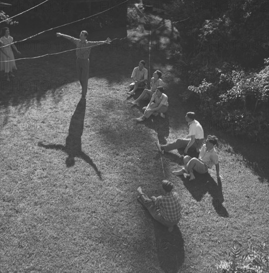 Dance rehearsal, Kenya. The long shadow of a ballet dancer, arms outstretched, extends across a lawn at a practice rehearsal for a square dance cabaret. Kenya, 7 December 1952. Kenya, Eastern Africa, Africa.