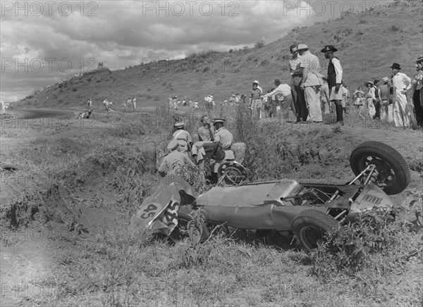 Cooper in the ditch. A Cooper racing car lies upturned in a ditch having veered off the track at the Langa Langa racing circuit. Lang Langa, Kenya, 21 December 1952. Kenya, Eastern Africa, Africa.