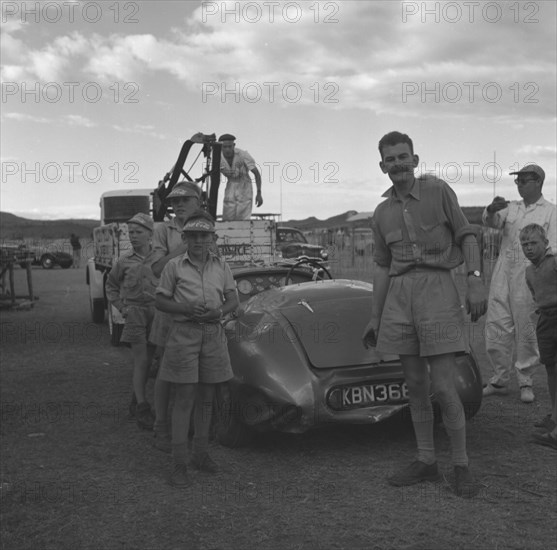 Recovery of a Connaught racing car. A curious group of onlookers gathers to watch the recovery of a Connaught racing car as it is towed away following a crash at the Langa Langa racing circuit. Langa Langa, Kenya, 21 December 1952. Langa Langa, Rift Valley, Kenya, Eastern Africa, Africa.