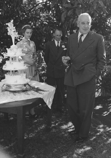Wedding speech. A middle-aged gentleman delivers the first of the speeches, drink in hand, at the Wendy Allen-Dudley Winter wedding. Kenya, 30 December 1952. Kenya, Eastern Africa, Africa.