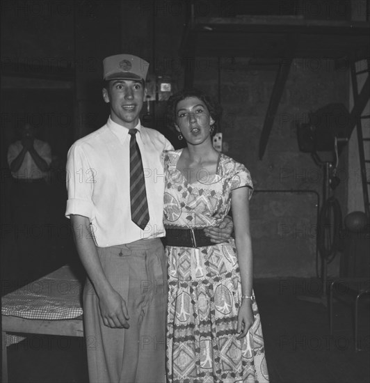 Bemused couple. A young couple pose for the camera, bemused expressions upon their faces, at a party being held for the last night of a performance of 'Cinderella'. Kenya, 1 January 1953. Kenya, Eastern Africa, Africa.