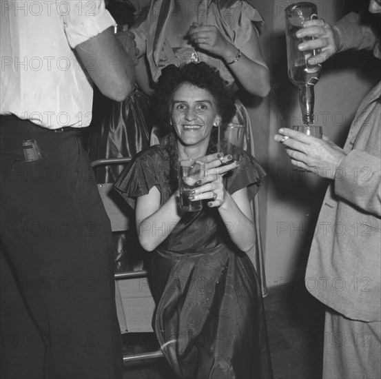 Last night of 'Cinderella'. A woman enjoys herself, drinks in hand, at a party being held for the last night of a performance of 'Cinderella'. Kenya, 1 January 1953. Kenya, Eastern Africa, Africa.