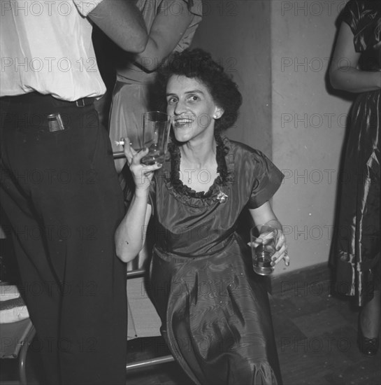Last night of 'Cinderella'. A woman enjoys herself, drinks in hand, at a party being held for the last night of a performance of 'Cinderella'. Kenya, 1 January 1953. Kenya, Eastern Africa, Africa.