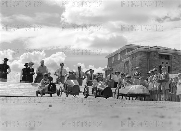 Soap box derby. Four young contestants wait tensely on the starting line for their cue to begin a soap box derby race. Kenya, 3 January 1953. Kenya, Eastern Africa, Africa.