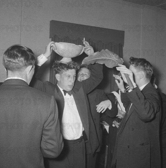 Rugby team antics. Members of a rugby team dressed in tuxedos fool around at the Mogambo Club. Possibly Nairobi, Kenya, 21 September 1957. Kenya, Eastern Africa, Africa.