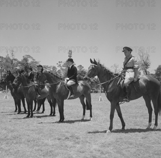 Open jumping winners. Riders in the open jumping competition at the Royal Show line up on horseback for the prize-giving ceremony. Kenya, 25 September 1957. Kenya, Eastern Africa, Africa.