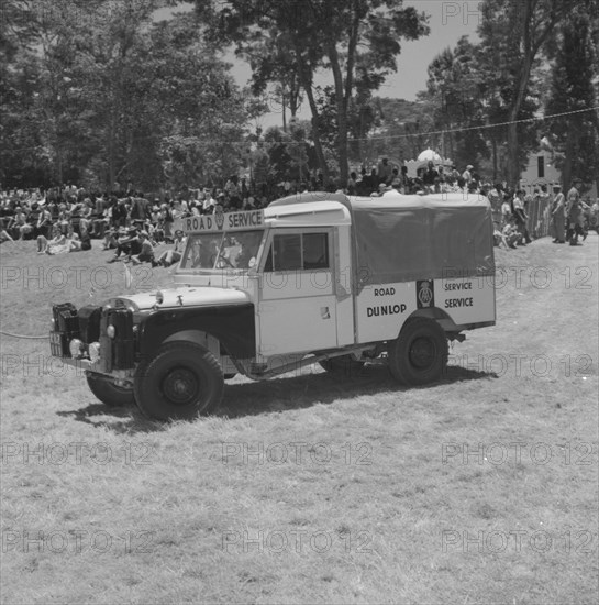 Road Service jeep. A jeep labelled 'Road Service' makes an appearance in a vehicle parade being held at the Royal Show. Kenya, 28 September 1957. Kenya, Eastern Africa, Africa.