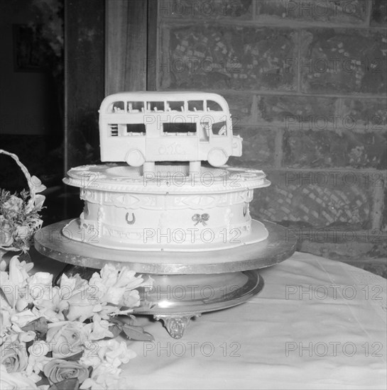 Double-decker cake. A novelty wedding cake, decorated with a miniature double-decker bus for Peter Stead's wedding. Kenya, 28 September 1957. Kenya, Eastern Africa, Africa.