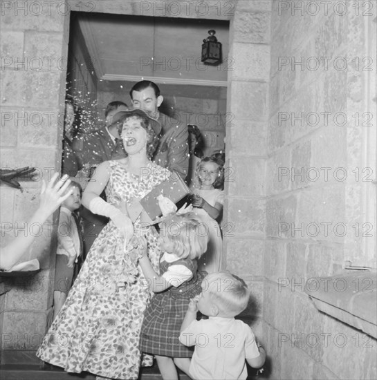 Silver-McPherson wedding. The newlywed Silver-McPherson couple attempt to depart for their honeymoon through showers of confetti and a sea of small children. Kenya, 5 October 1957. Kenya, Eastern Africa, Africa.