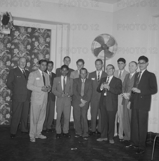 Kodak cocktail party. Mixed race staff employed by Kodak pose for a group portrait at a company cocktail party. Kenya, 8 October 1957. Kenya, Eastern Africa, Africa.