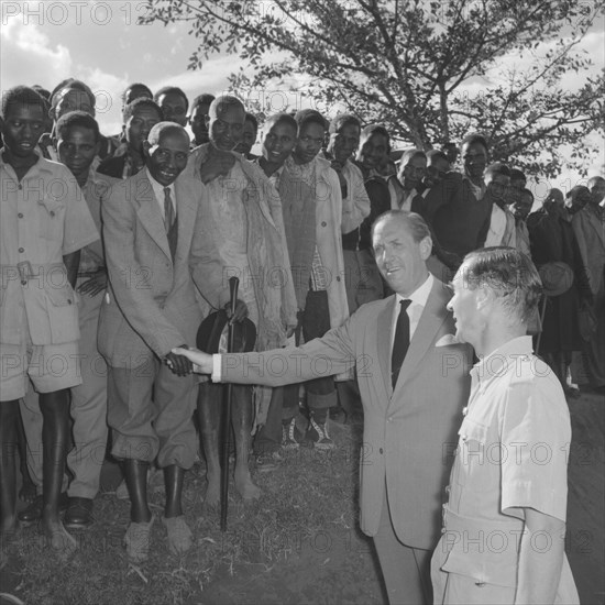 Lennox-Boyd visits Fort Hall. Publicity shot of Alan Tindal Lennox-Boyd (1904-1983) shaking the hand of an elderly Kenyan man during his visit to the Fort Hall district. Kangema, Kenya, 15 October 1957. Kangema, Central (Kenya), Kenya, Eastern Africa, Africa.