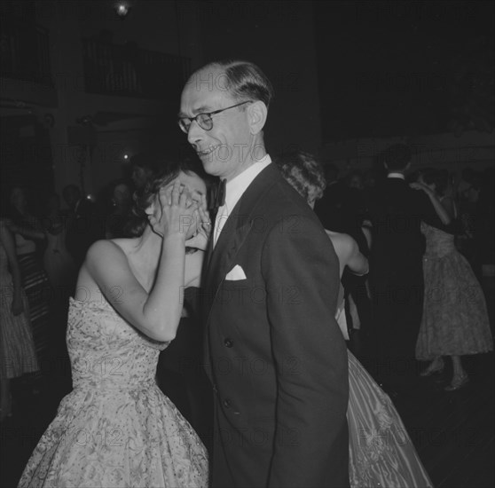 Guests at the Limuru Hunt Ball. A couple dancing at the Limuru Hunt Ball react to the camera: the woman covering her face with her hands, her partner grimacing. Kenya, 19 October 1957. Kenya, Eastern Africa, Africa.