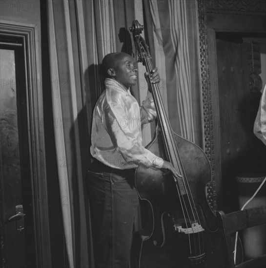 Double bass player. An African musician smiles broadly as he plays a double bass during a performance at the Equator Club. Nairobi, Kenya, 19 October 1957. Nairobi, Nairobi Area, Kenya, Eastern Africa, Africa.